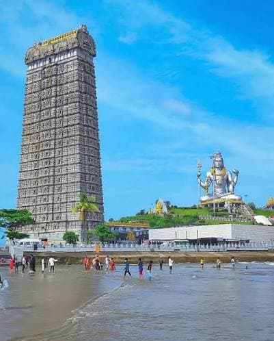 Murudeshwar Temple and Shiva statue seen from the beach, with the Raja Gopura and seated statue above the shoreline